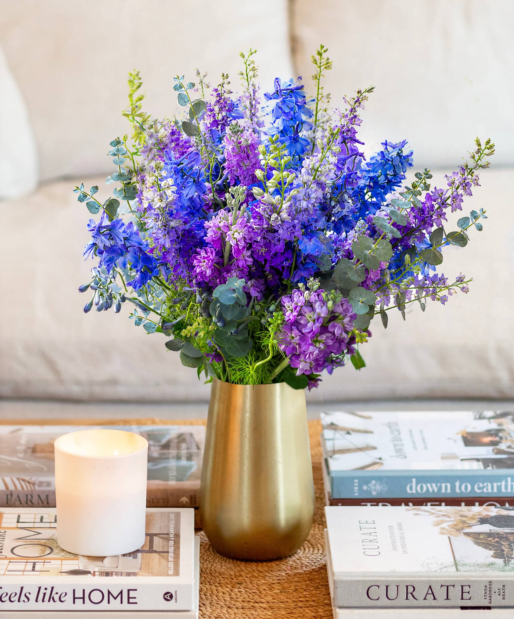 A vibrant bouquet of purple and blue flowers in a gold vase, perfect for home decor.